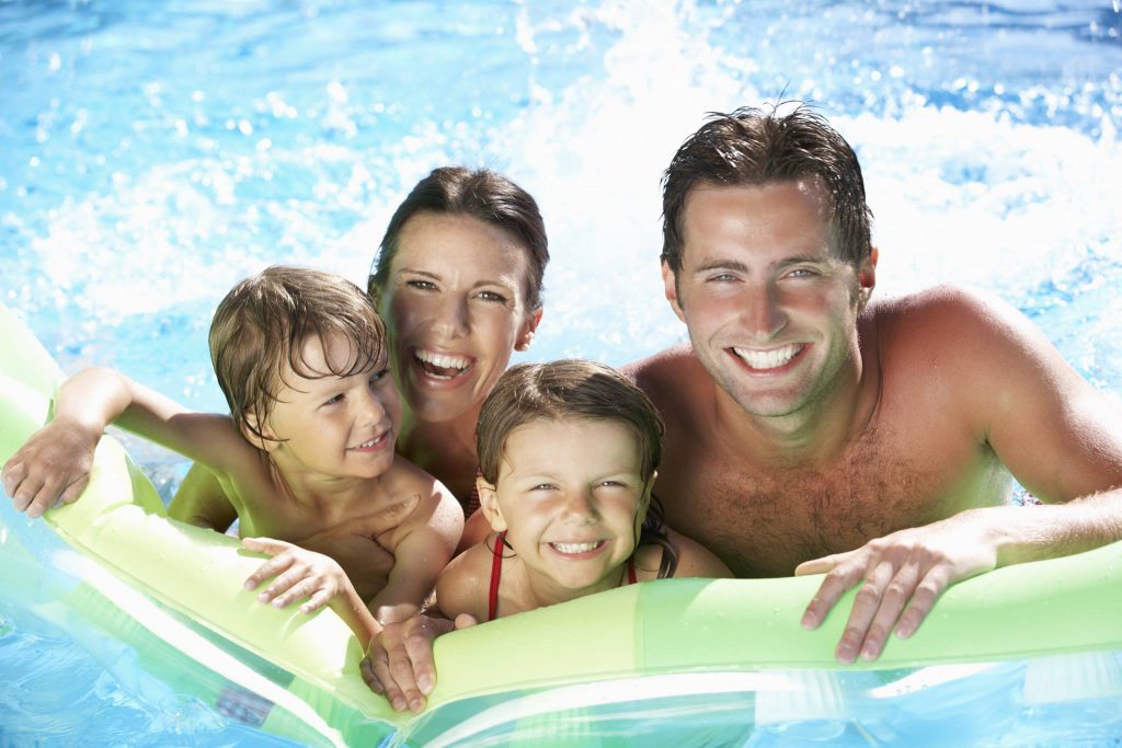 Mother, father and 2 children on a floaty in a swimming pool